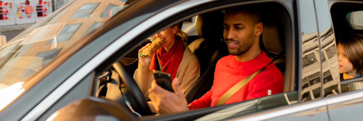 Man and woman in car with child at car charging station