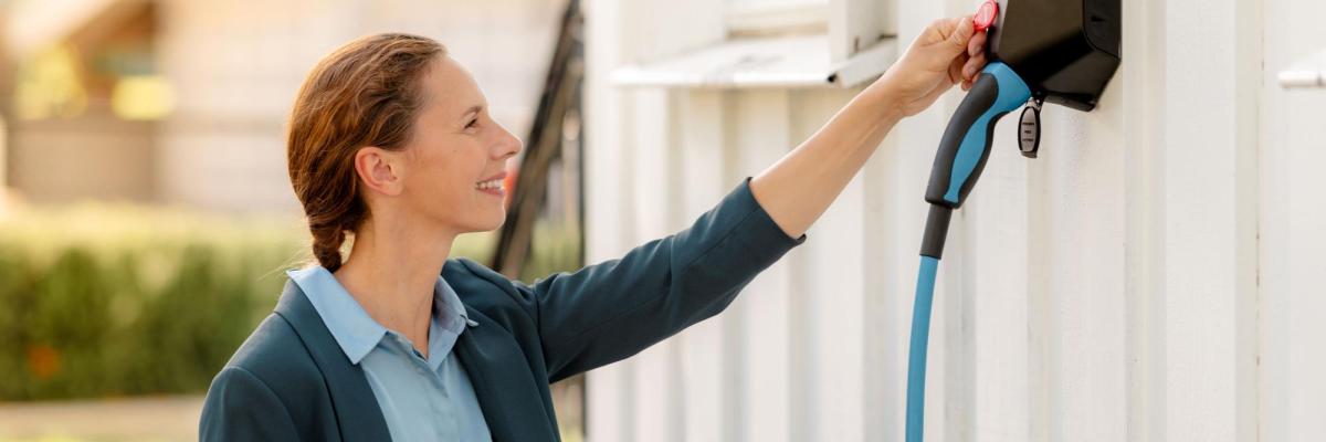 en dame som bruker en elbillader