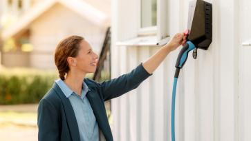 en dame som bruker en elbillader