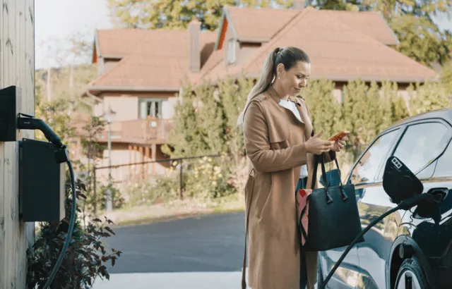 Dame som lader bilen hjemme