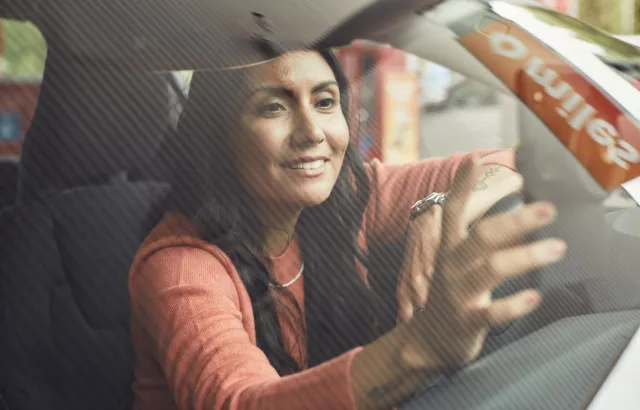 Kvinne inne i bil på bensinstasjon