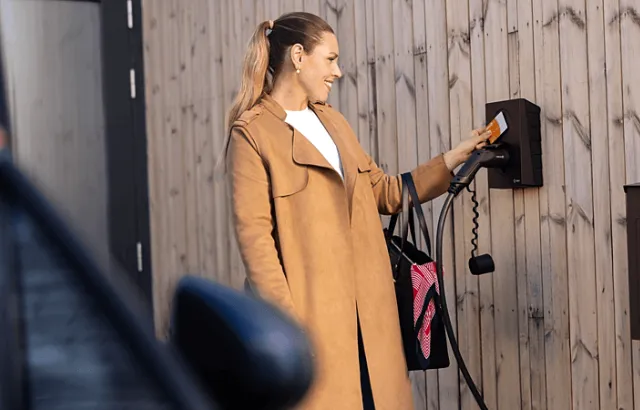 Bilde av dame som lader hjemme med firmakort