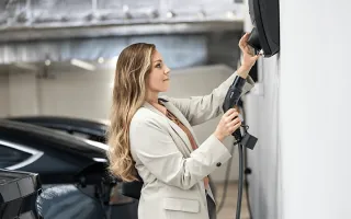 dame som lader bilen på jobben