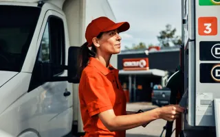 Kvinne foran bensinpumpe