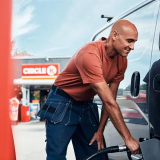 Mann fyller tanken på varebil