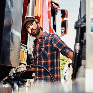 Mann fyller tanken på lastebil