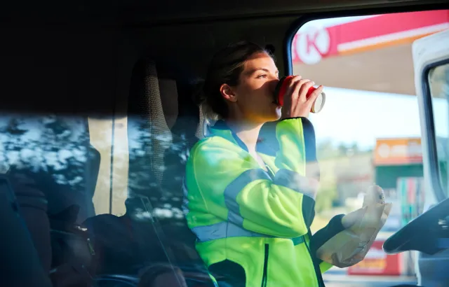 Woman drinking coffee getting into her truck at a Circle K station