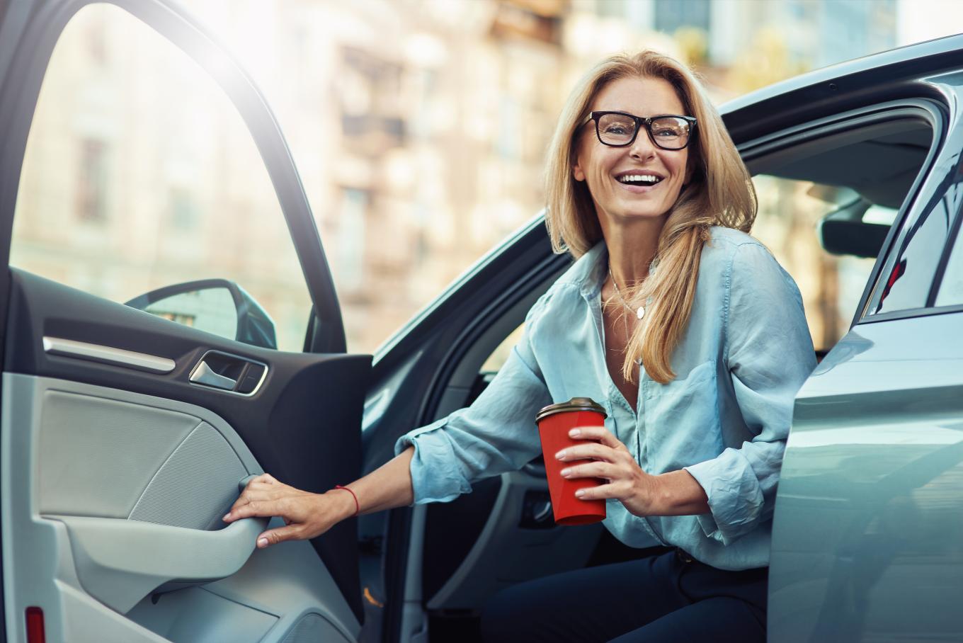 Bilde av glad dame i bil